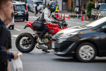 Téléchargez les photos : Tokyo, Japon, 2 Novembre 2023 : Scène de circulation avec motocycliste et voitures en mouvement flou - en image libre de droit