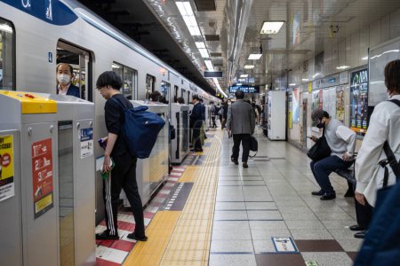 Foto de Tokio, Japón, 2 de noviembre de 2023: Pasajeros abordando un tren en una estación de metro de Tokio - Imagen libre de derechos