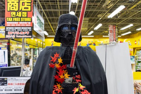 Foto de Tokio, Japón, 2 de noviembre de 2023: Persona disfrazada de Darth Vader rodeada de texto japonés en una tienda - Imagen libre de derechos