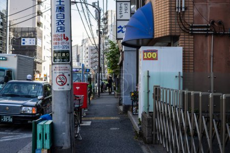 Foto de Tokio, Japón, 2 de noviembre de 2023: Callejuela con pequeñas empresas y señalización direccional - Imagen libre de derechos