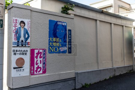 Téléchargez les photos : Tokyo, Japon, 2 novembre 2023 : Affiches sur un mur de la ville annonçant des entreprises et des services locaux - en image libre de droit