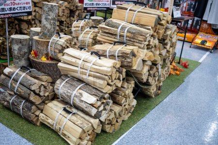 Photo for Tokyo, Japan, 2 November 2023: Stacked firewood for sale at outdoor market - Royalty Free Image