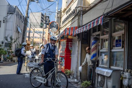 Téléchargez les photos : Tokyo, Japon, 2 Novembre 2023 : Police Officer on Bicycle Patrol in Tokyo Neighborhood - en image libre de droit