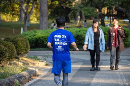 Foto de Tokio, Japón, 3 de noviembre de 2023: Runner in a blue shirt with event text participa en un evento de triatlón - Imagen libre de derechos