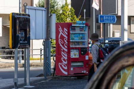 Photo for Tokyo, Japan, 3 November 2023: Person Using Vending Machine Near Parking Lot - Royalty Free Image