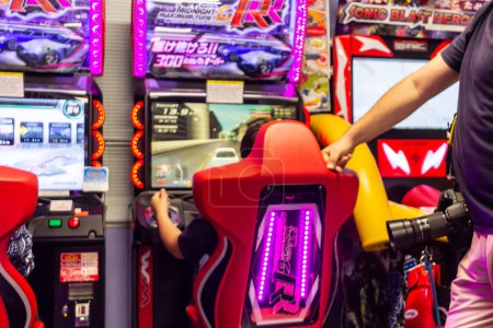 Foto de Tokio, Japón, 3 de noviembre de 2023: Gente jugando juegos de carreras arcade en Tokio Game Center - Imagen libre de derechos