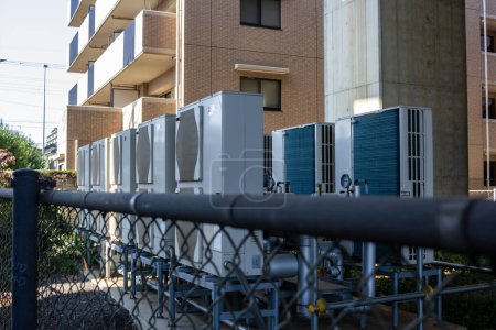 Foto de Tokio, Japón, 3 de noviembre de 2023: Unidades de aire acondicionado instaladas fuera de un edificio residencial - Imagen libre de derechos