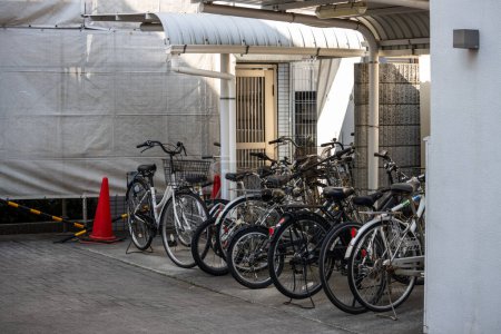 Téléchargez les photos : Tokyo, Japon, 3 novembre 2023 : Vélos garés à côté d'une passerelle couverte dans une zone urbaine - en image libre de droit