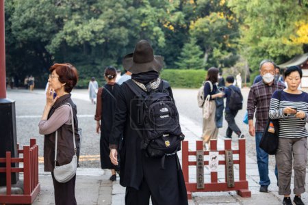 Téléchargez les photos : Tokyo, Japon, 3 novembre 2023 : Femme parlant sur un téléphone portable près de l'entrée du sanctuaire Meiji - en image libre de droit