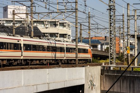 Foto de Tokio, Japón, 3 de noviembre de 2023: Tren que pasa por la zona residencial con líneas eléctricas aéreas - Imagen libre de derechos