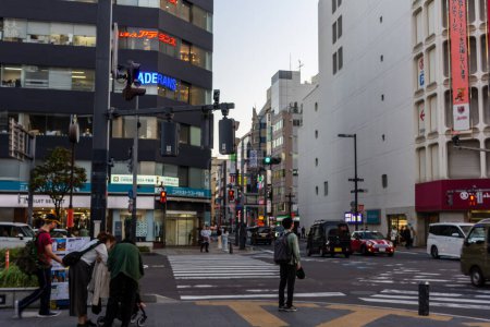 Téléchargez les photos : Tokyo, Japon, 3 novembre 2023 : Un coin de rue occupé avec des piétons et une enseigne de pharmacie - en image libre de droit