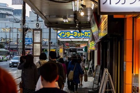 Téléchargez les photos : Tokyo, Japon, 3 novembre 2023 : Des piétons marchent sous un trottoir couvert dans une zone commerçante animée - en image libre de droit
