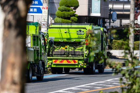 Téléchargez les photos : Tokyo, Japon, 3 novembre 2023 : Camion à ordures vert dans les rues de Tokyo - en image libre de droit