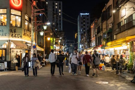 Foto de Tokio, Japón, 4 de noviembre de 2023: animada escena nocturna en Tokio con peatones y restaurantes locales - Imagen libre de derechos