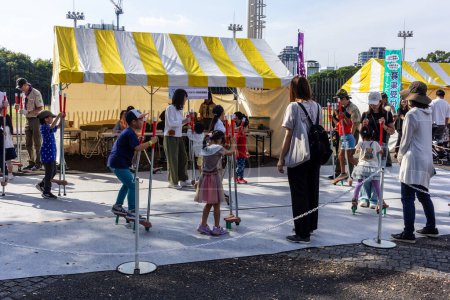 Téléchargez les photos : Tokyo, Japon, 4 Novembre 2023 : Les familles profitent d'un festival local avec des échasses traditionnelles jeu - en image libre de droit