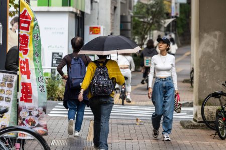 Téléchargez les photos : Tokyo, Japon, 4 Novembre 2023 : Piétons marchant dans le passé Bannière de restaurant japonais traditionnel un jour nuageux - en image libre de droit