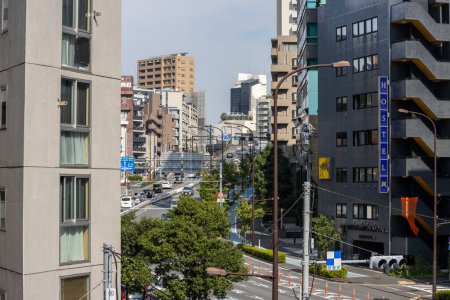 Foto de Tokio, Japón, 4 de noviembre de 2023: Vista bulliciosa de la calle con letrero de albergue y paso elevado en el corazón de la ciudad - Imagen libre de derechos