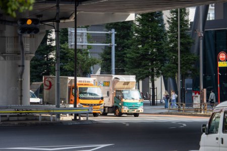 Foto de Tokio, Japón, 4 de noviembre de 2023: Camiones de reparto estacionados en una concurrida calle Tokio - Imagen libre de derechos