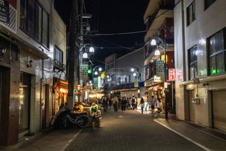 Foto de Tokio, Japón, 4 de noviembre de 2023: Escena nocturna en un callejón tradicional japonés con comensales y linternas - Imagen libre de derechos