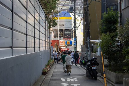 Téléchargez les photos : Tokyo, Japon, 4 novembre 2023 : Un trottoir animé à Tokyo avec des piétons et une vue sur le restaurant Gyukaku - en image libre de droit