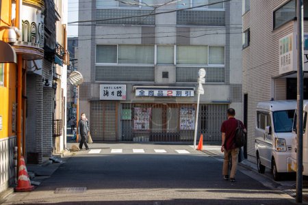 Foto de Tokio, Japón, 4 de noviembre de 2023: Escena callejera cotidiana con peatones y escaparate tradicional japonés - Imagen libre de derechos