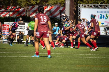 Foto de Tokio, Japón, 4 de noviembre de 2023: Dynamic Women 's Rugby Match with Maroon Team in Possession - Imagen libre de derechos
