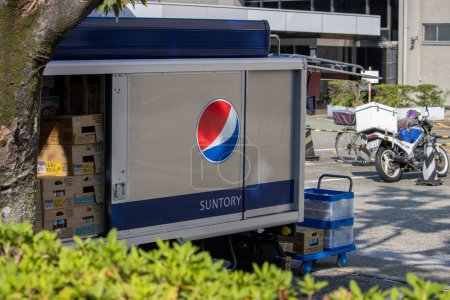Photo for Tokyo, Japan, 4 November 2023: Suntory and PepsiCo Branded Delivery Truck Parked on Urban Street - Royalty Free Image