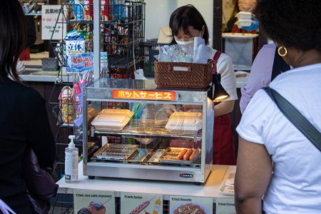 Téléchargez les photos : Tokyo, Japon, 4 novembre 2023 : Vendeur de rue vendant des hot-dogs et des collations frites à Tokyo - en image libre de droit