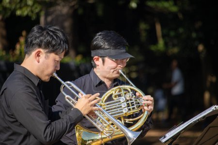 Téléchargez les photos : Tokyo, Japon, 4 novembre 2023 : Duo de musiciens jouant avec trompette et cor français en plein air - en image libre de droit