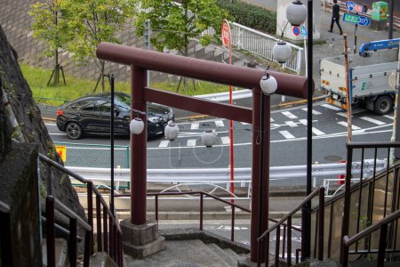 Téléchargez les photos : Tokyo, Japon, 4 novembre 2023 : Escalier urbain avec porte traditionnelle Torii donnant sur la rue occupée - en image libre de droit
