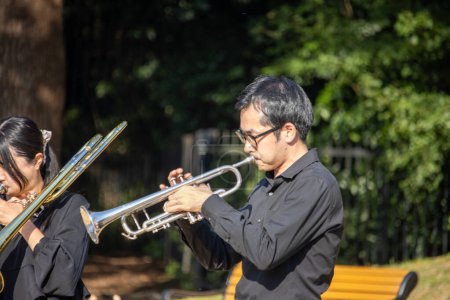 Photo for Tokyo, Japan, 4 November 2023: Musicians Performing in Outdoor Concert with Trumpet and Trombone - Royalty Free Image