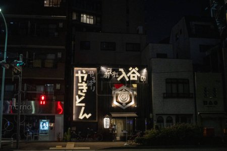 Foto de Tokio, Japón, 4 de noviembre de 2023: Señalización iluminada de un distrito comercial de Tokio por la noche - Imagen libre de derechos