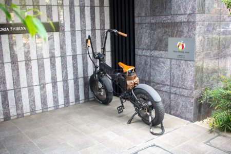 Photo for Tokyo, Japan, November 4 2023 : Electric Bicycle Parked Outside Modern Building - Royalty Free Image
