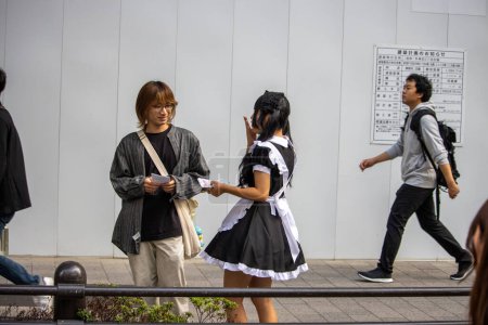 Photo for Tokyo, Japan, November 5 2023: Maid Cafe Employee Handing Out Flyers - Royalty Free Image