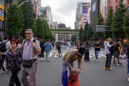 Téléchargez les photos : Tokyo, Japon, 5 novembre 2023 : Passage piéton achalandé avec des gens divers et panneaux d'affichage urbains - en image libre de droit