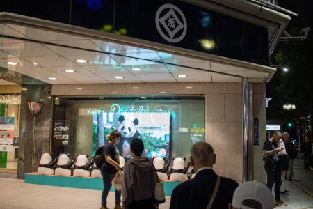Téléchargez les photos : Tokyo, Japon, 6 novembre 2023 : Passants observant l'affichage du panda dans la devanture - en image libre de droit
