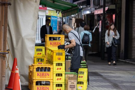 Téléchargez les photos : Tokyo, Japon, 6 novembre 2023 : Delivery Man Organizing Beer Crates - en image libre de droit