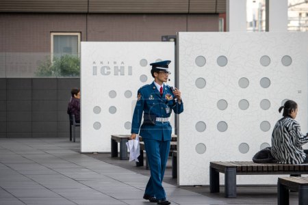 Photo for Tokyo, Japan, November 6, 2023: Security guard communicating via radio - Royalty Free Image