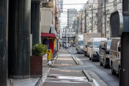 Photo for Tokyo, Japan, November 6, 2023: Urban Street Scene with Parked Vehicles - Royalty Free Image