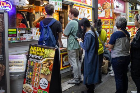 Téléchargez les photos : Tokyo, Japon, 6 novembre 2023 : Les clients faisant la queue dans un étal de restauration de rue - en image libre de droit