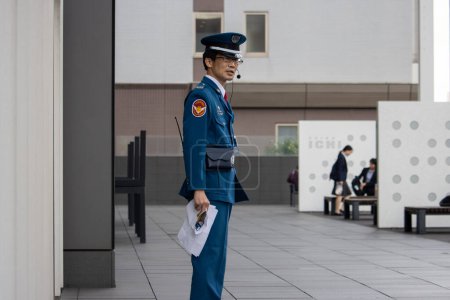 Photo for Tokyo, Japan, 6 November 2024: Japanese security guard standing at his post - Royalty Free Image