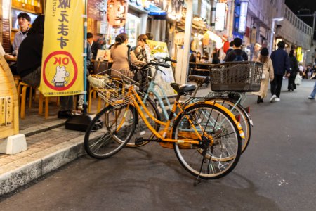 Foto de Tokio, Japón, 7 de noviembre de 2024: Escena nocturna con bicicletas y comensales - Imagen libre de derechos