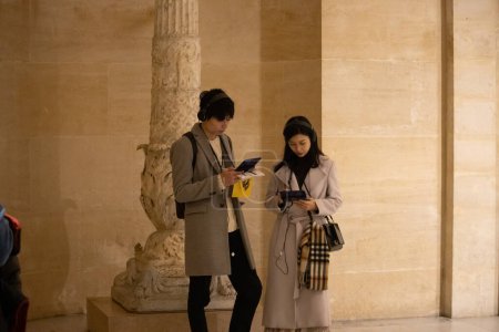 Foto de París, Francia, 9 de noviembre de 2024: Pareja usando la tecnología en el museo - Imagen libre de derechos