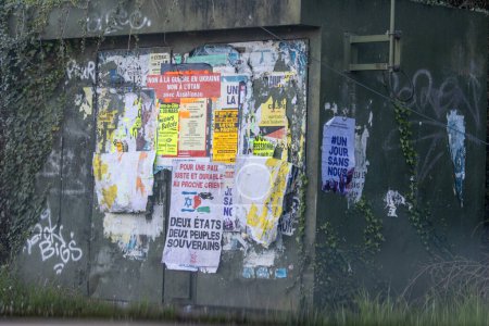 Francja, 30 marca 2024 r.: Plakaty uliczne na ścianie zachmurzonej