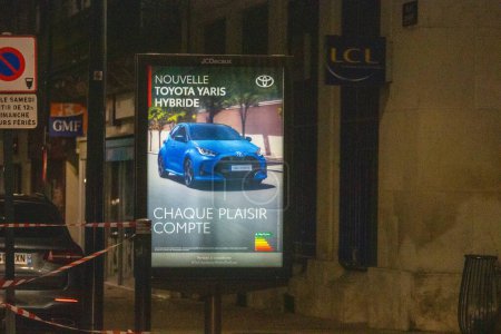 Téléchargez les photos : France, 21 Mars 2024 : Vue Nocturne de la Rue Urbaine avec Voiture Hybride Publicité - en image libre de droit