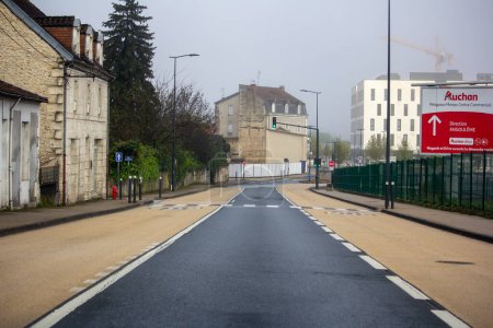 Photo for France, 30 March 2024: Urban street view with Auchan supermarket signage on a foggy day - Royalty Free Image