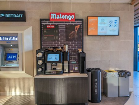 Foto de Francia, 14 de marzo de 2024: cajero automático y estación de café en un entorno de cafetería urbana con prominente marca Malongo. - Imagen libre de derechos
