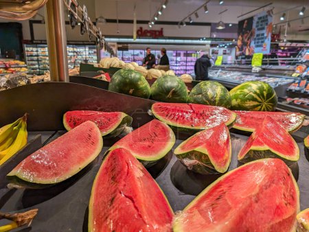 Téléchargez les photos : France, 25 Avril, 2024 : Des tranches de pastèque fraîche exposées dans une section de produits de supermarché - en image libre de droit