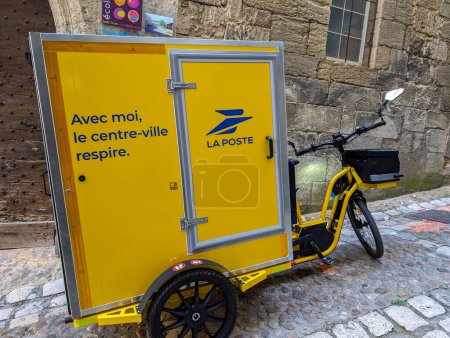 Téléchargez les photos : France, 22 Avril 2024 : Tricycle de livraison Jaune La Poste stationné sur une rue pavée dans le centre-ville. - en image libre de droit