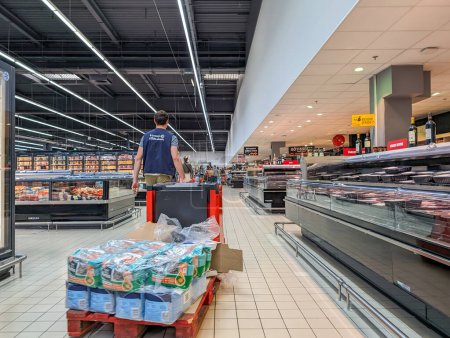 Téléchargez les photos : France, 08 Mai 2024 : Allée des supermarchés avec travailleur transportant des marchandises sur une palette - en image libre de droit